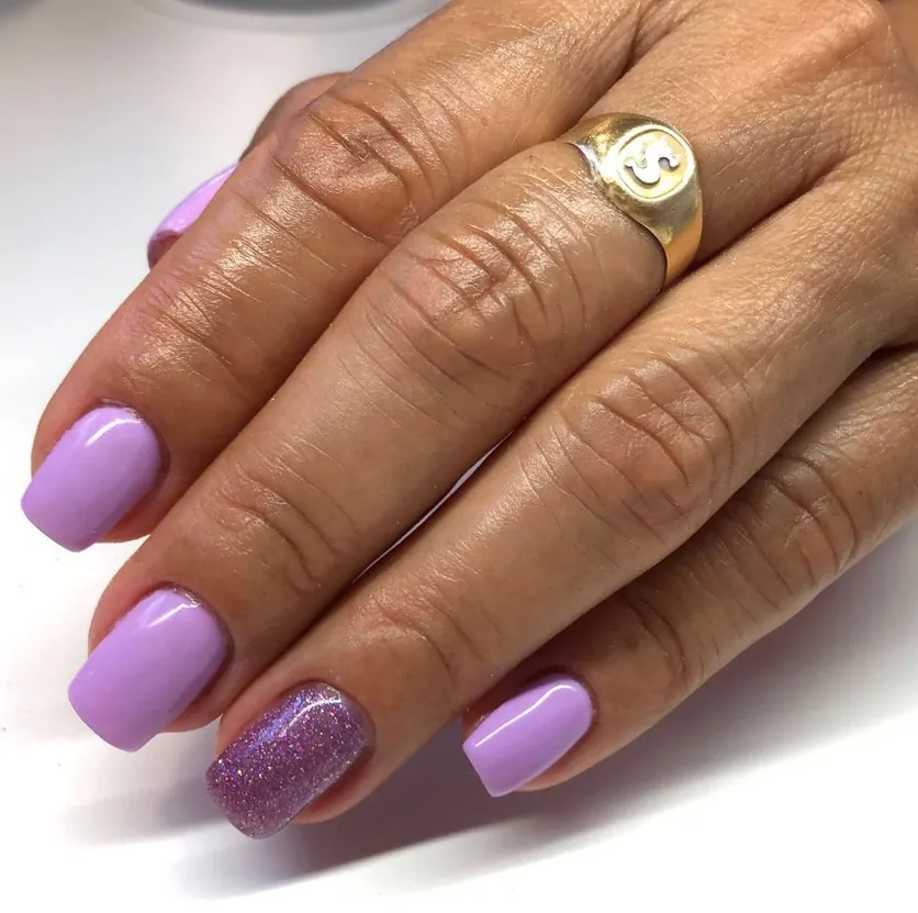 Unhas quadradas lilás com uma unha em glitter