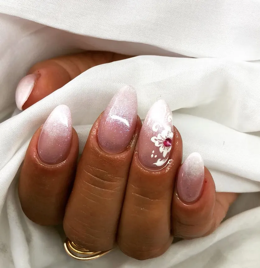 Unhas em ombré rosa e branco com flor pintada à mão e cristal
